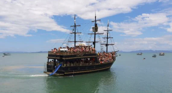 Barco pirata lotado navegando com o toboágua azul